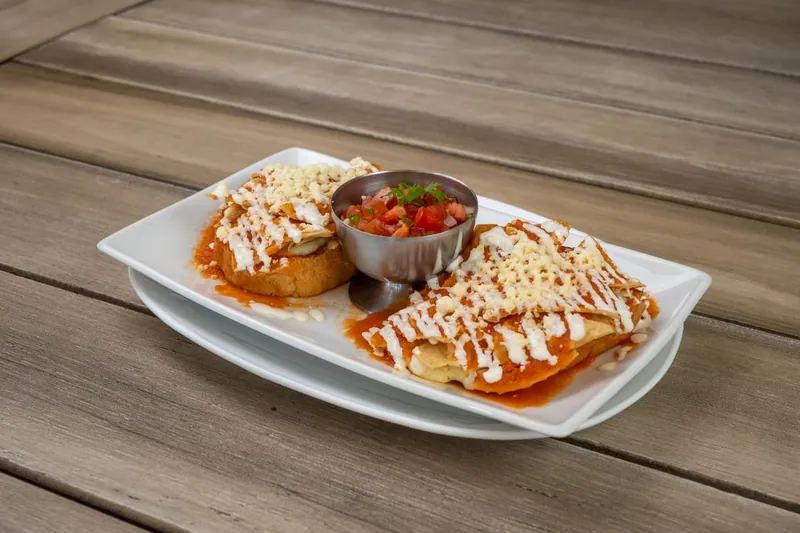 Cheesy enchiladas covered with red sauce and served with fresh salsa