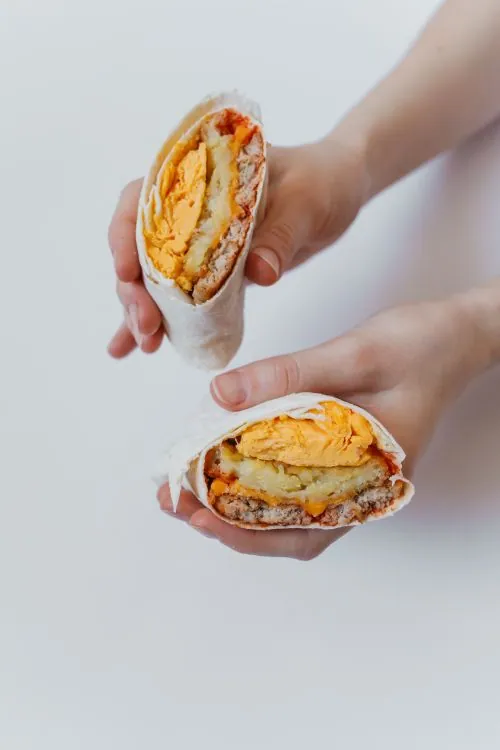 Breakfast burrito halves filled with eggs, potatoes, and cheese