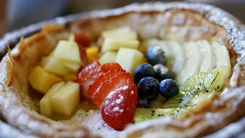 Puffed Dutch baby pancake in a skillet topped with fresh berries