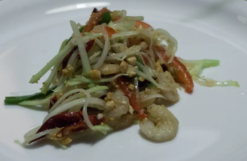 Thai-style shrimp som tam with cooked shrimp, shredded green papaya, tomato, long beans and crushed peanuts in lime dressing