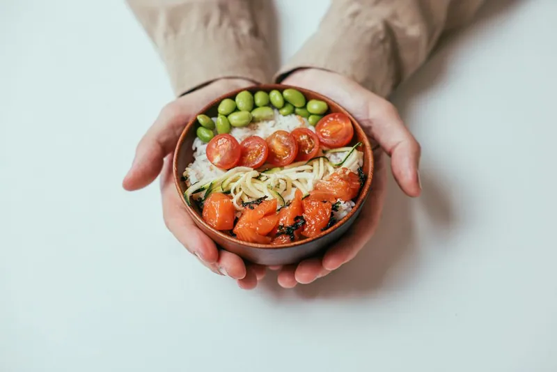 Salmon rice bowl with edamame, tomatoes, and greens