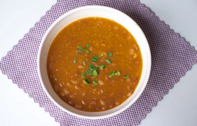 Hearty bean stew garnished with green onions