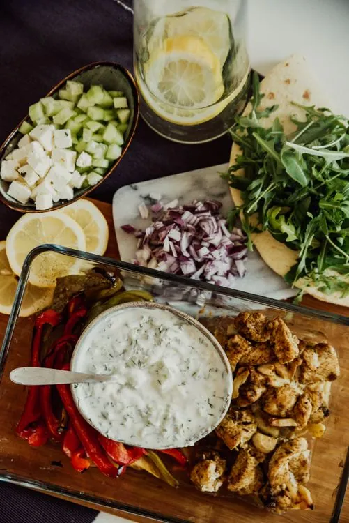Greek chicken bowl with feta, peppers, red onion, and tzatziki