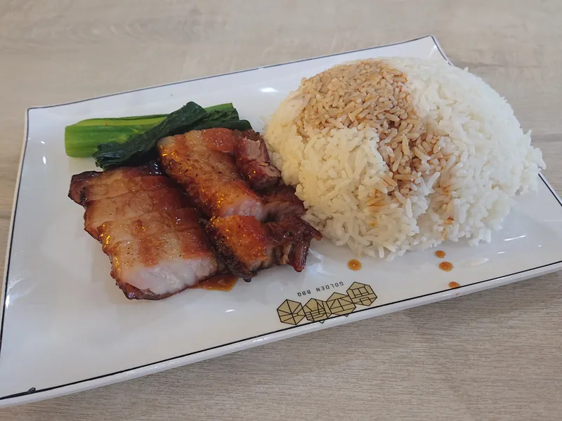 Sliced lacquered char siu pork belly served with white rice and cooked Chinese greens