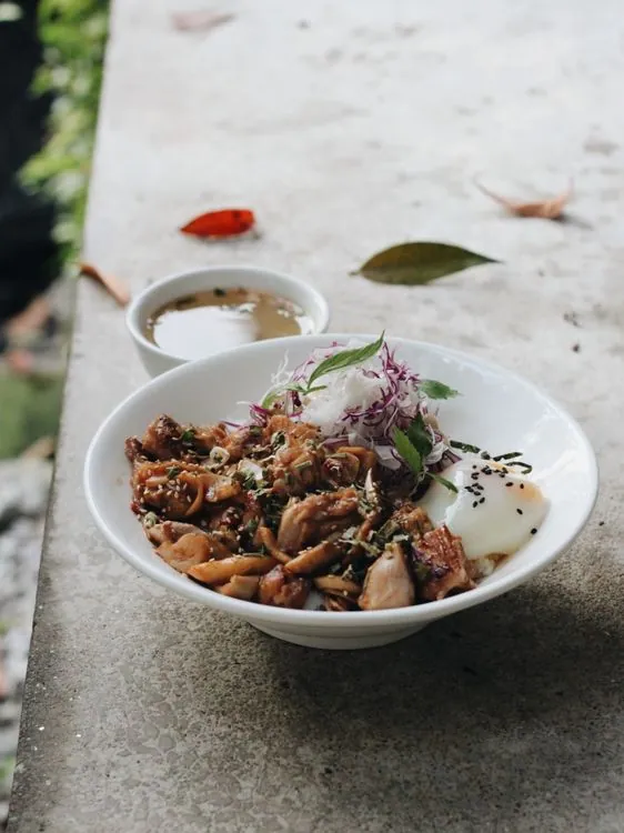 Teriyaki chicken rice bowl with a soft egg, sesame, and greens