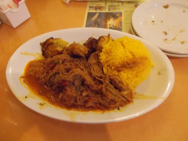 Cuban-style shredded beef in tomato sauce served with yellow rice and caramelized plantains