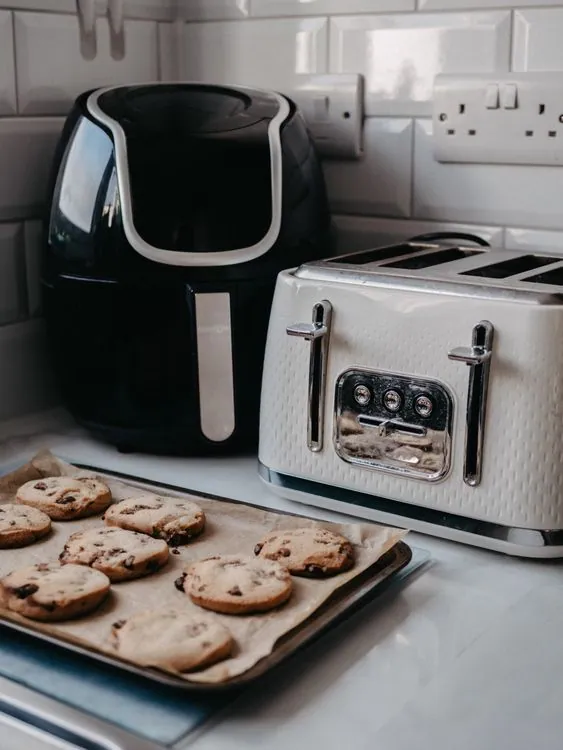 Countertop air fryer beside a toaster in a home kitchen