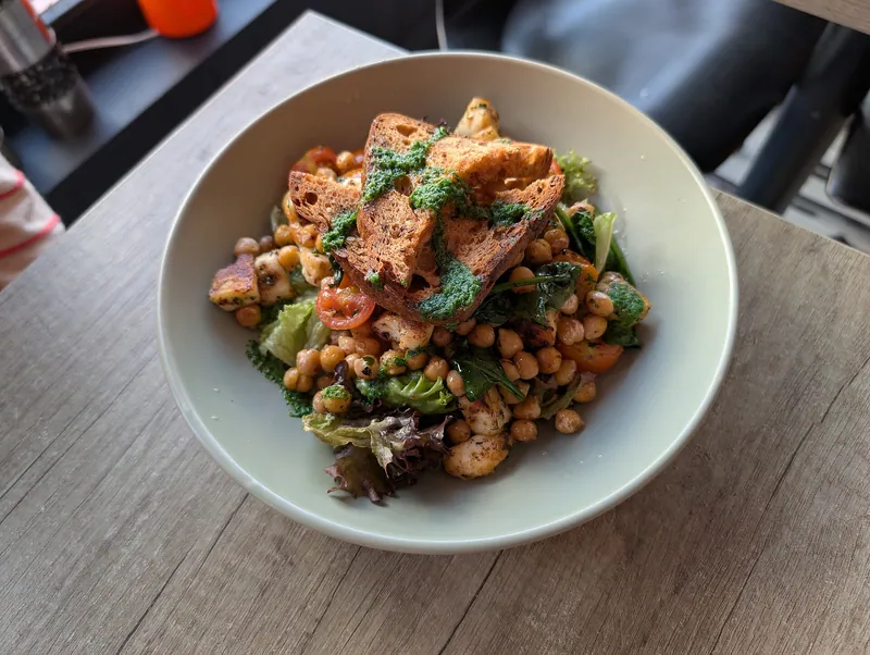 Warm salad with golden halloumi cubes, crisp chickpeas, cherry tomatoes, leafy greens and herb-dressed sourdough toast