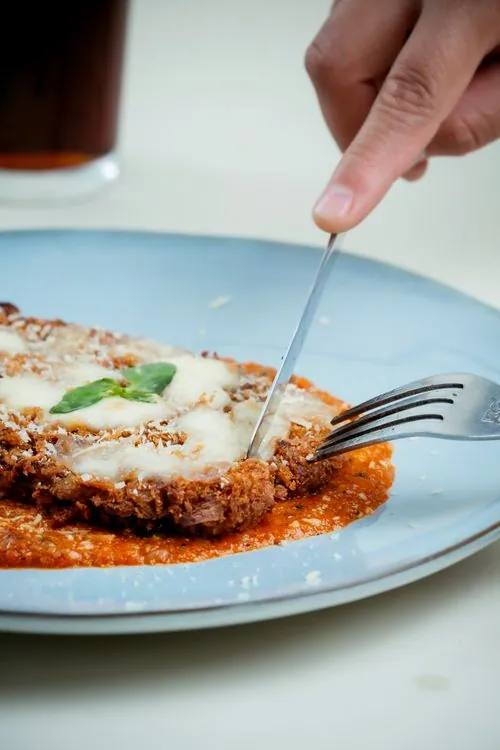 Crispy chicken Parmesan with tomato sauce, melted cheese, and basil