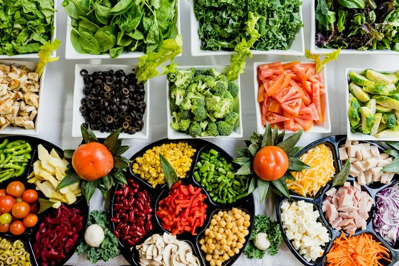 Fresh ingredients and meal-prep containers on a kitchen table