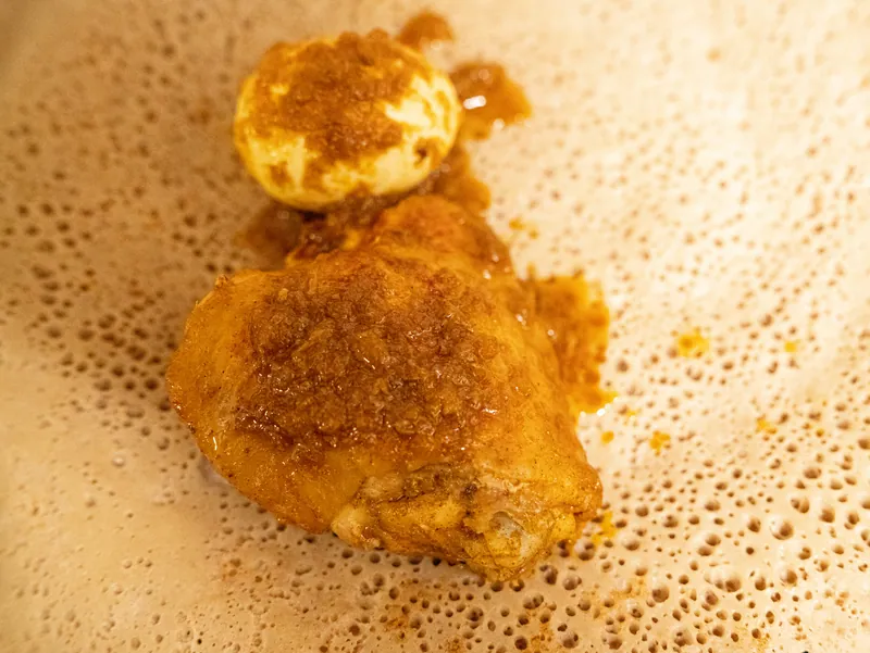 Ethiopian doro wat with a chicken leg and hard-cooked egg served on injera