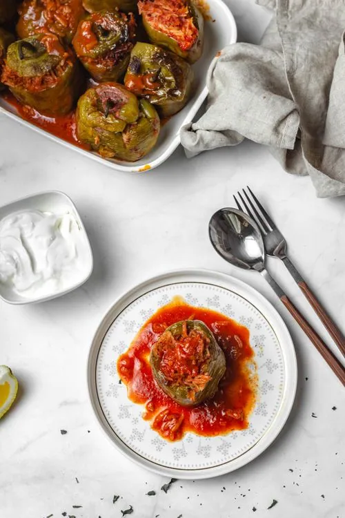 Ground beef and rice stuffed bell peppers baked and served with rich tomato sauce and fresh herbs
